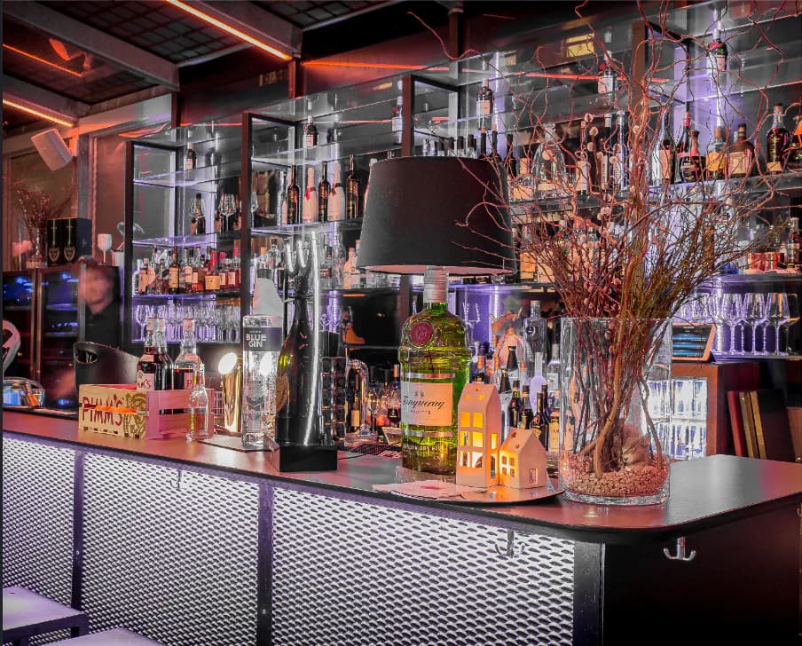 Bar counter at Rooftop7 with illuminated spirits shelves